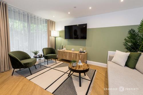 a living room with a couch and chairs and a tv at Aurora Heights by Grandeur Property in Poole