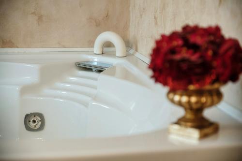 a white sink with a vase of red flowers on it at Charming & Luxury Villa Como Lake in Como