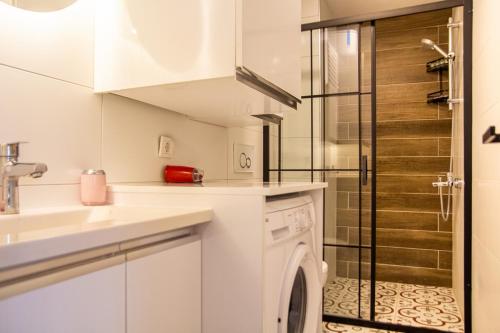 a white kitchen with a washing machine and a shower at Colorful and Central Flat near Kulturpark Izmir in Izmir