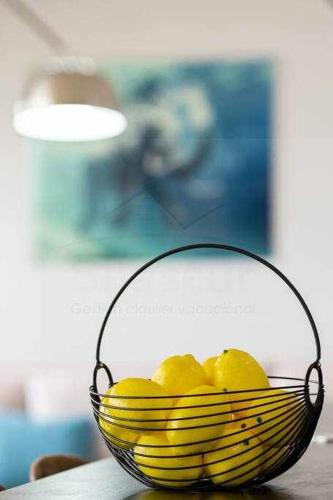 a glass bowl of lemons and a basket of bananas at El Séptimo, Apartamento in Gijón