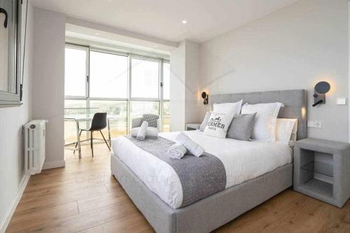 a bedroom with a large bed and a large window at El Séptimo Apartamento in Gijón