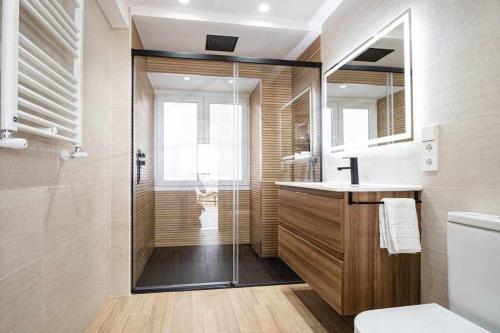a bathroom with a shower and a toilet and a sink at El Séptimo, Apartamento in Gijón