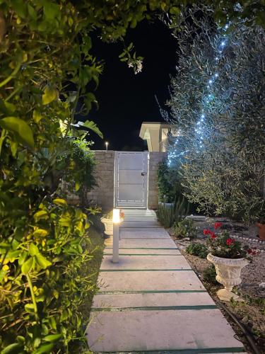 a garden path at night with a gate and lights at Oasi della pace in Bisceglie