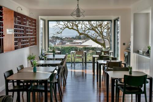 a restaurant with tables and chairs and a large window at Volcanic Charming House in Ribeira Grande