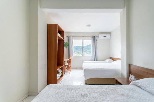 a hotel room with two beds and a window at Hotel Dom Rafael Express in Santa Maria