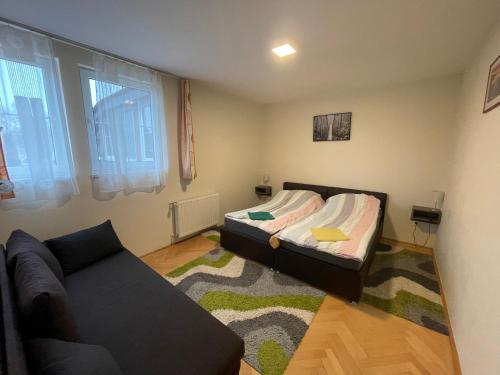 a small bedroom with a bed and a couch at Künszler Apartmanház in Zamárdi