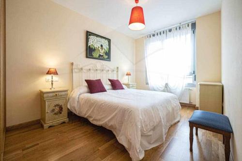 a bedroom with a large white bed and a window at Casina de Dante in San Juan de la Arena