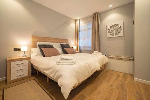 Un dormitorio con una cama grande y una ventana en Dindurra Apartamento en Gijón