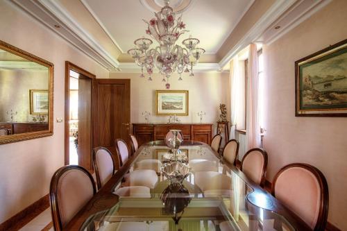 a dining room with a glass table and a chandelier at Charming & Luxury Villa Como Lake in Como