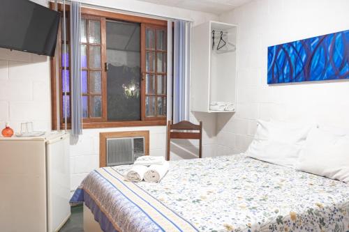 - une chambre avec un lit et des serviettes dans l'établissement Pousada Estrela da Manhã, à São Pedro da Serra