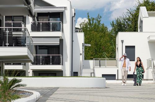 a man and a woman walking in front of a building at The Black Pearl Villas in Kalamitsi