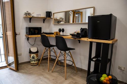 um quarto com uma secretária com 2 cadeiras e uma televisão em Geometric Art Home em Bari