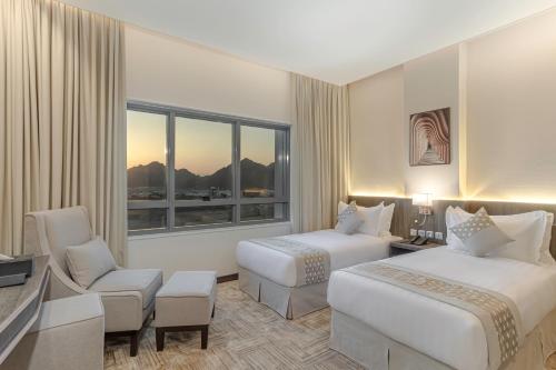 a hotel room with two beds and a window at The Seasons Hotel in Al Madinah
