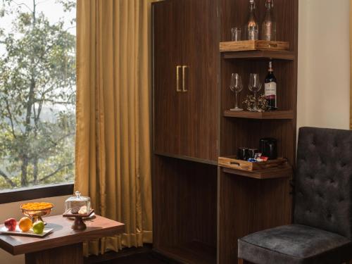 a room with a chair and a table and a window at Tree of Life Indra Mandala Hotel, Gangtok in Gangtok