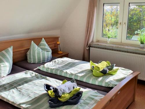 two beds in a hotel room with towels on them at Ferienhaus Nordseeblick in Norddeich