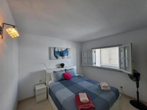 Un dormitorio con una cama azul y una ventana en Apartamento Gaviota, en Playa Blanca
