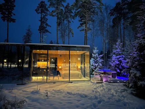 a glass house in the snow at night at 7Mirrors in Murjāņi