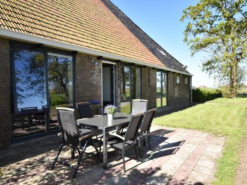 un patio con mesa y sillas frente a una casa en Rural holiday home with a lovely sunny terrace, en Workum