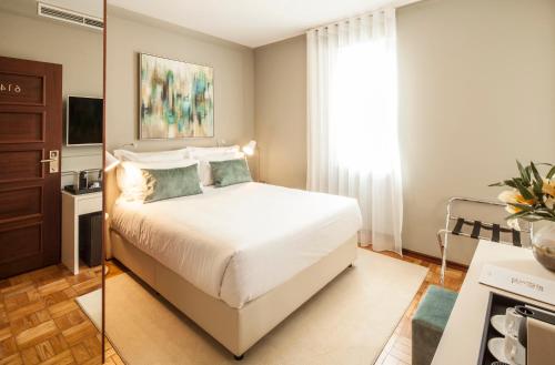 1 dormitorio con cama blanca y ventana en Luzeiros Suites en Lisboa