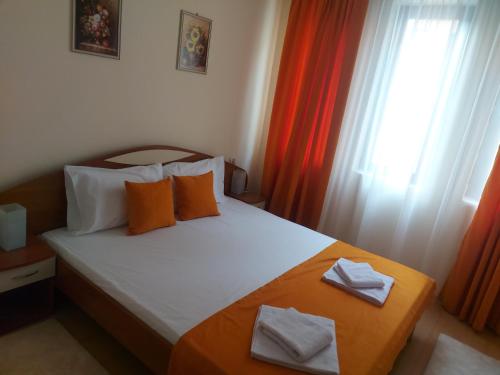 a bedroom with a bed with orange and white pillows at Angel&MAR in Velingrad