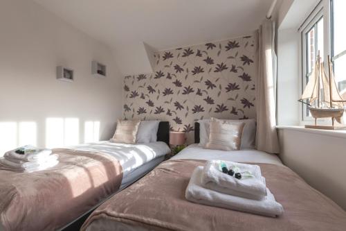 a bedroom with two beds and a window at Chichester retreat house with free parking in Chichester