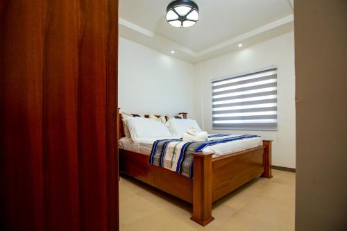 a bedroom with a bed with a window in it at 3-Bedroom Apartment in Tema - Chez Akwasi in Tema