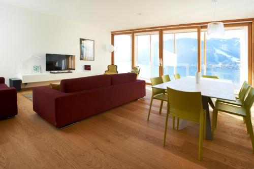 a living room with a couch and a table and chairs at Residence Bellevue - incl Summercard in Zell am See
