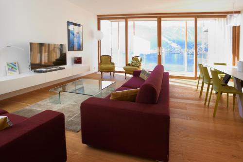 a living room with a red couch and a glass table at Residence Bellevue - incl Summercard in Zell am See