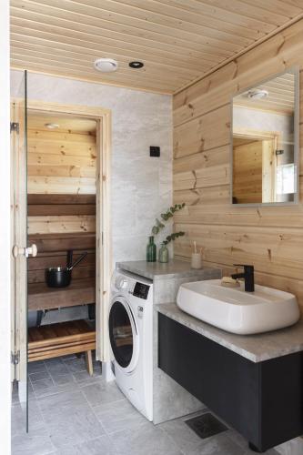 a bathroom with a washing machine and a sink at Break Sokos Hotel Tykkimäki Resort in Kouvola