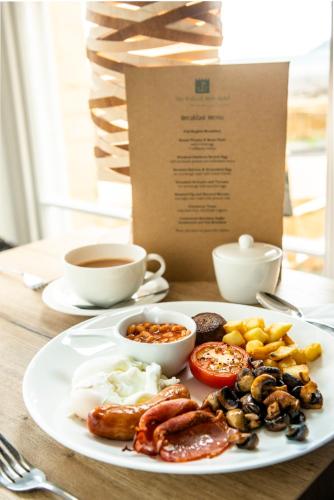 a plate of breakfast food on a table with a cup of coffee at The Porlock Weir Hotel in Porlock