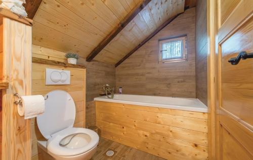 a wooden bathroom with a toilet and a tub at Kuća za odmor Josip in Gospić