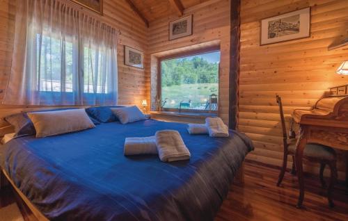 a bedroom with a blue bed in a log cabin at Kuća za odmor Josip in Gospić
