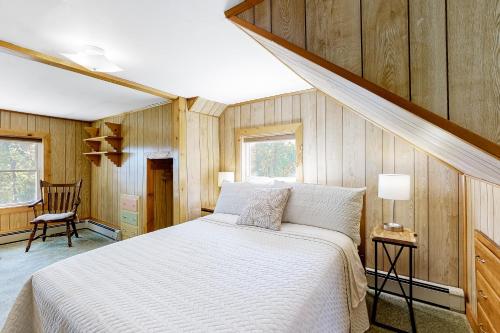 sypialnia z dużym łóżkiem w pokoju z drewnianymi ścianami w obiekcie Bayview Retreat w mieście Bowdoinham