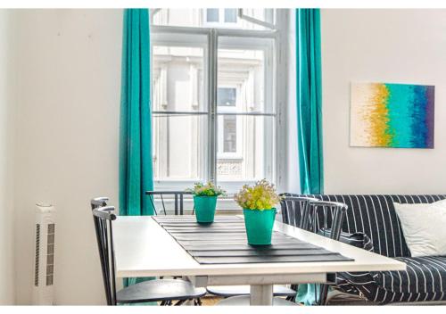 a dining room table with two potted plants on it at 4 Charming Apts. Perfect for 19 persons (6BRs) in Vienna