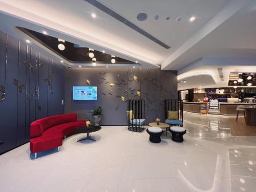 a living room with a red couch and tables at Centara Life Hotel Bangkok Phra Nakhon in Bangkok