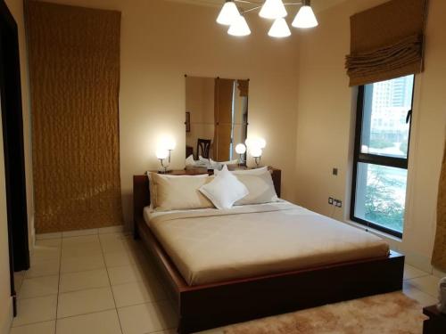 Un dormitorio con una cama con almohadas blancas y una ventana en Burj Dubai Area - 5min Walk - Luxury 2 Bedroom Apartment, en Dubái