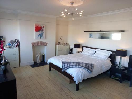 a bedroom with a bed with white sheets and pillows at Palsgrave Lodge in Cheltenham