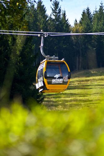 a yellow helicopter flying over a field of grass at Pensjonat Eldorado in Świeradów-Zdrój