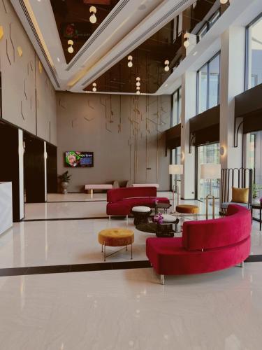 a lobby with red chairs and tables at Centara Life Hotel Bangkok Phra Nakhon in Bangkok