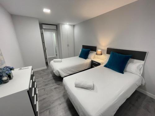 Cette petite chambre comprend deux lits et une table. dans l'établissement D.A.U. Centro Free Parking, à Salamanque