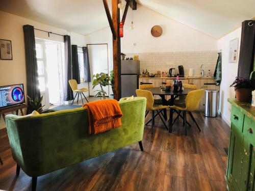 a living room with a green couch and a table at B &B Yuupke Maasbree Noord-Limburg Venlo Roermond in Maasbree