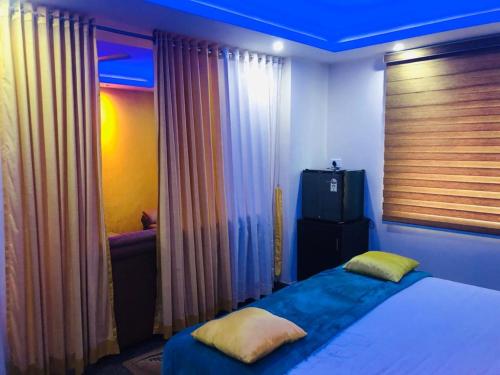a bedroom with a bed with a blue ceiling at Ashoka Residency Chottanikkara in Chottanikara