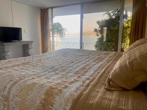 1 dormitorio con 1 cama y vistas al océano en Marina Palace Teques en Tequesquitengo