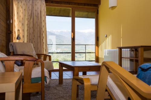a living room with a table and a large window at La Hospedería Del Silencio in Robledillo de la Vera