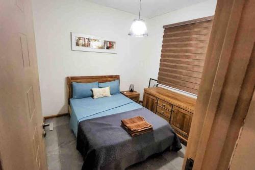 Schlafzimmer mit einem blauen Bett und einem Kopfteil aus Holz in der Unterkunft Mungur villa in Flic-en-Flac