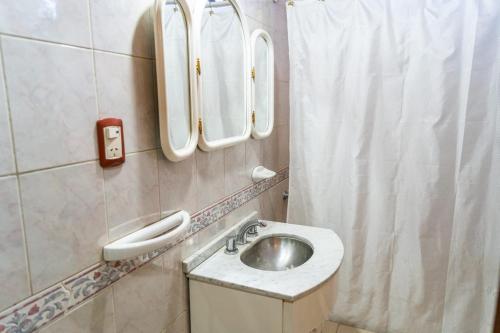 a bathroom with a sink and mirrors on the wall at Casa Rosa in San Juan