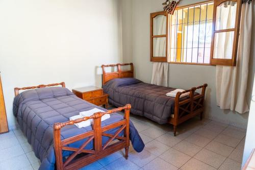 a bedroom with two beds and a window at Casa Rosa in San Juan