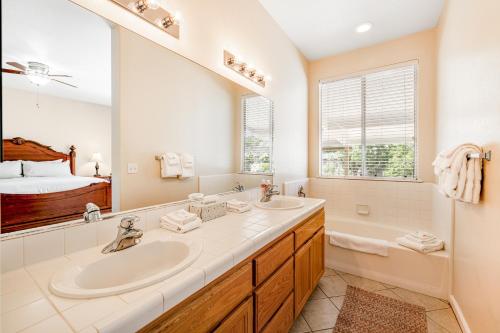 een badkamer met een wastafel, een bad en een spiegel bij Wine Country Getaway in Windsor