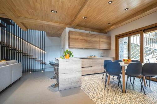 cocina con techos de madera, mesa y sillas en La Quintana Berbes, en Ribadesella