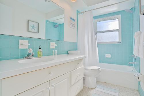 uma casa de banho com um lavatório, um WC e um espelho. em Corner By The Coast em Largo